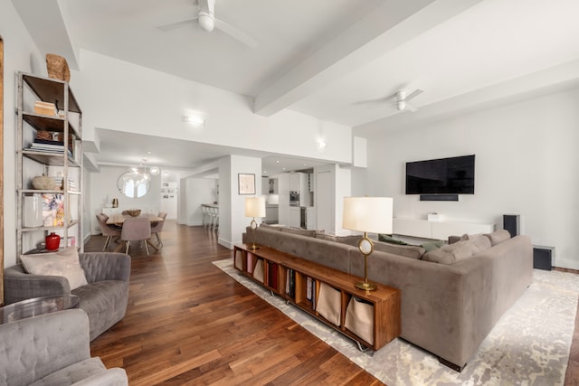 living room featuring hardwood / wood-style floors, ceiling fan with notable chandelier, and beamed ceiling