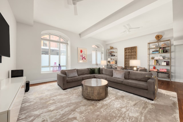 living area with ceiling fan, baseboards, beam ceiling, and wood finished floors