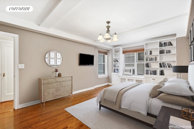 bedroom featuring baseboards, visible vents, a chandelier, and wood finished floors