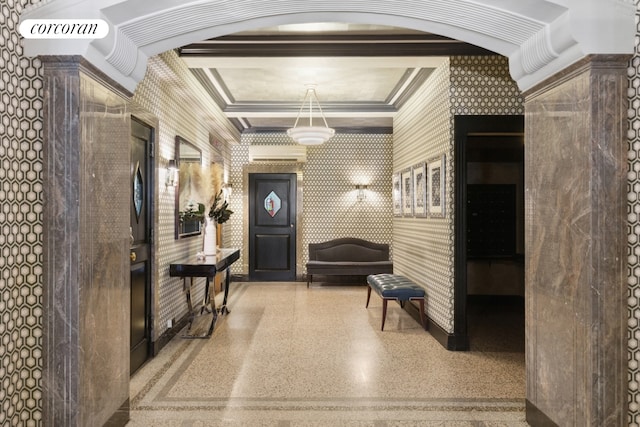 hallway with ornamental molding, wallpapered walls, and speckled floor