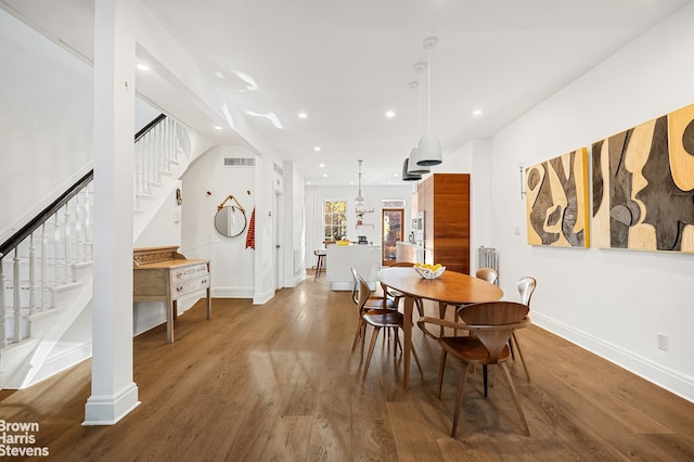 dining area with dark hardwood / wood-style flooring and radiator heating unit