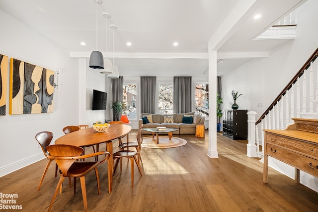 dining room featuring beam ceiling and hardwood / wood-style floors