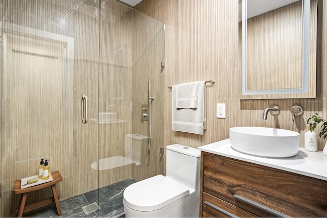 full bathroom featuring vanity, a shower stall, toilet, and tile walls