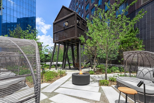 view of patio / terrace with an outdoor fire pit and a balcony