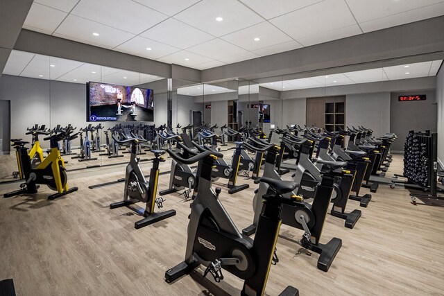 workout area with wood finished floors, a paneled ceiling, and recessed lighting