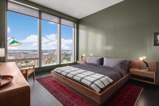 bedroom with a water view and wood finished floors