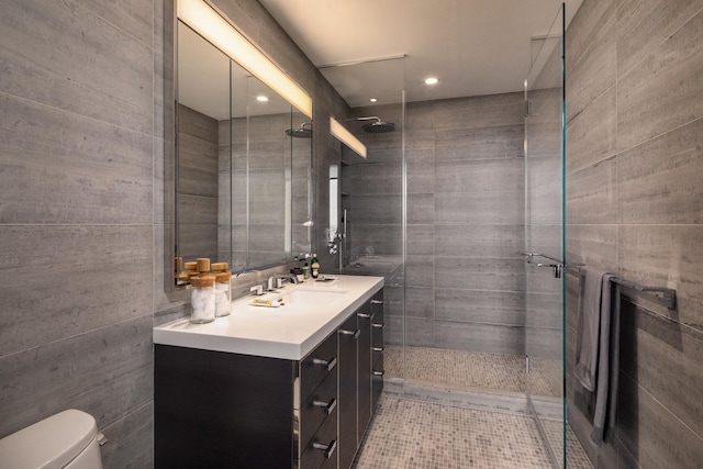 full bathroom featuring tile walls, recessed lighting, toilet, a shower stall, and vanity