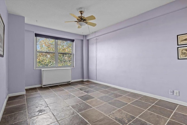 spare room with radiator and ceiling fan