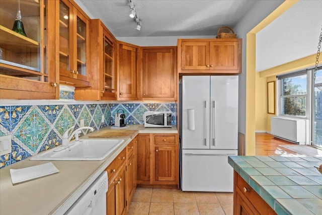 kitchen featuring light tile patterned flooring, sink, high quality fridge, dishwasher, and backsplash