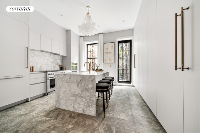 kitchen featuring stainless steel stove, visible vents, white cabinetry, decorative backsplash, and modern cabinets