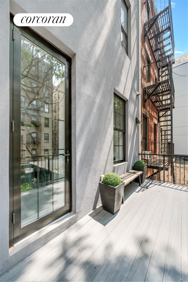 entrance to property featuring a balcony and stucco siding