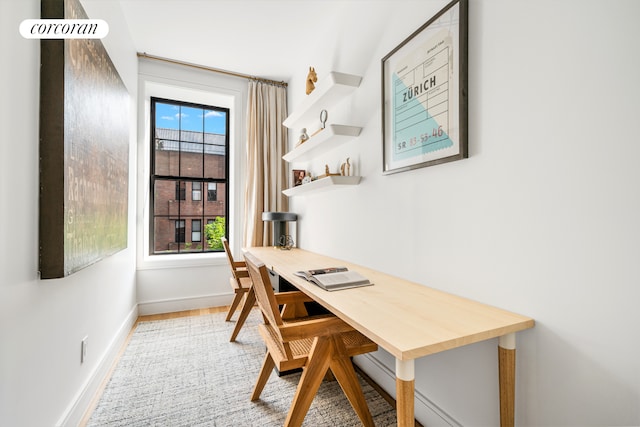 office featuring a healthy amount of sunlight, baseboards, and wood finished floors