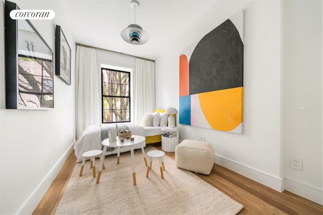 living area featuring baseboards and wood finished floors