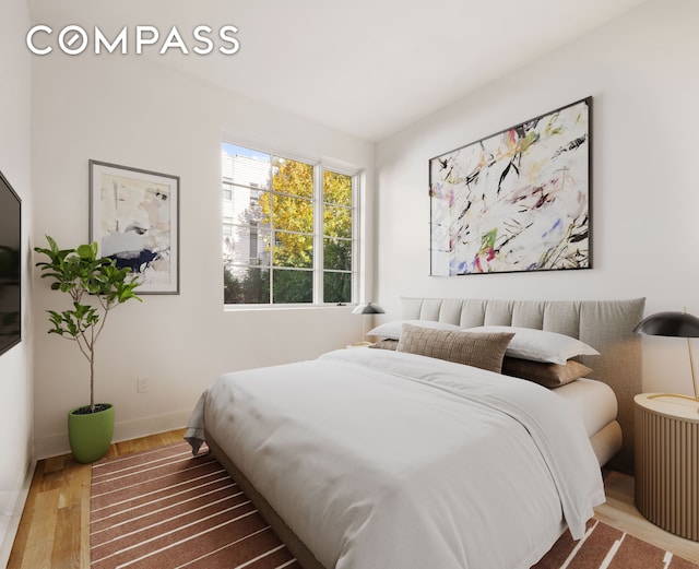 bedroom featuring baseboards and wood finished floors