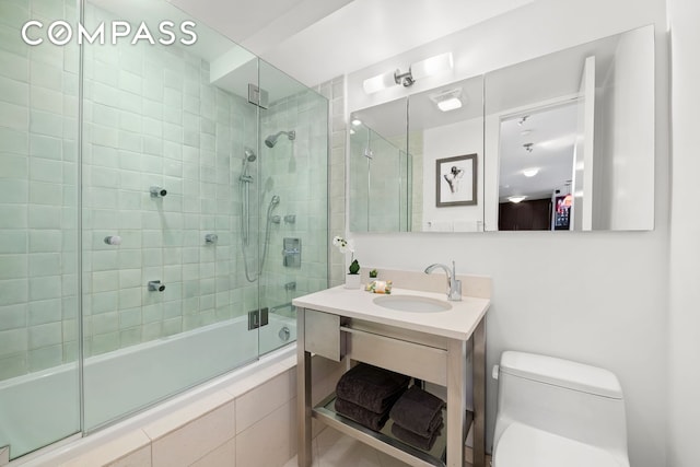 bathroom featuring toilet, vanity, and tiled shower / bath combo