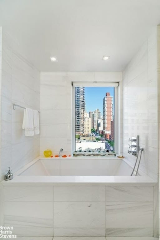 bathroom featuring tiled tub