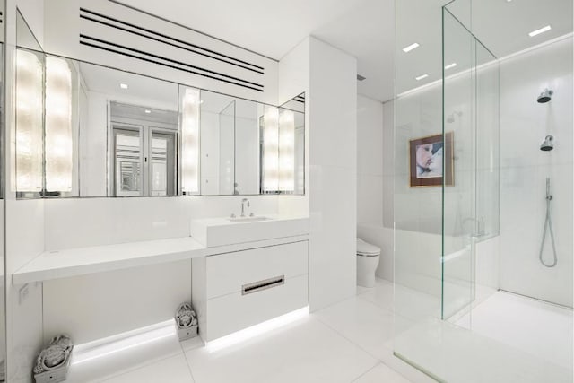 bathroom featuring tile patterned flooring, walk in shower, vanity, and toilet