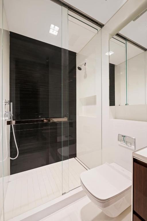 bathroom with vanity, a shower with shower door, and toilet