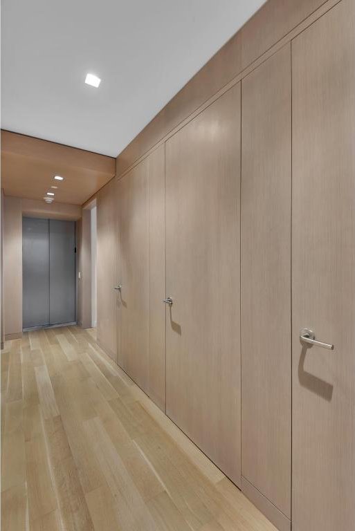 hall featuring elevator and light wood-type flooring