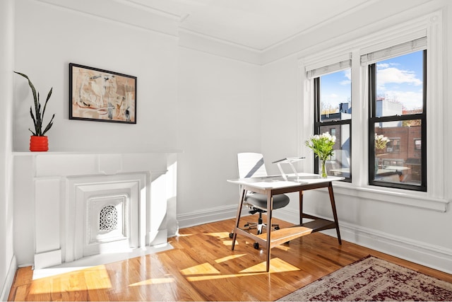 office with baseboards, light wood finished floors, and crown molding