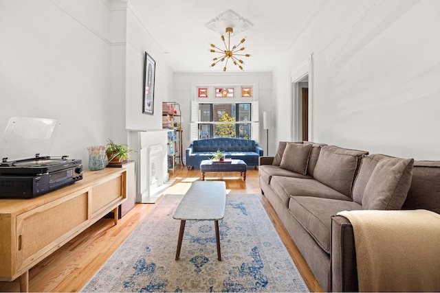 living room featuring a notable chandelier, crown molding, and light wood finished floors