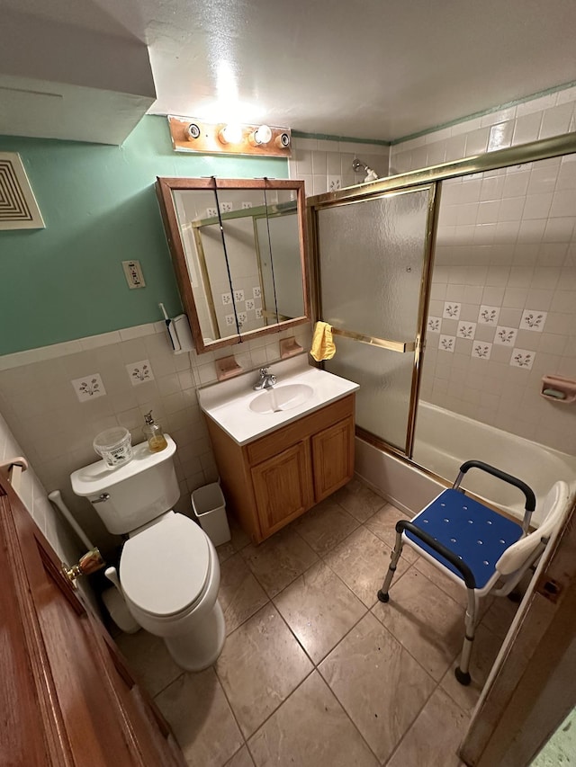 229 Nichols Ave, New York City, NY 11208 - bathroom featuring toilet, vanity, enclosed tub / shower combo, tile walls, and a wainscoted wall