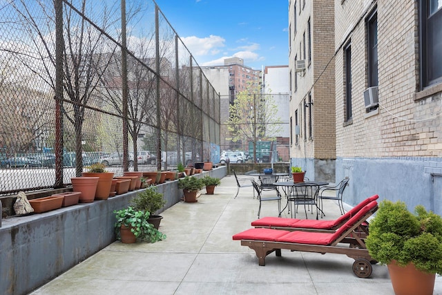 view of community featuring fence, a patio, and outdoor dining area