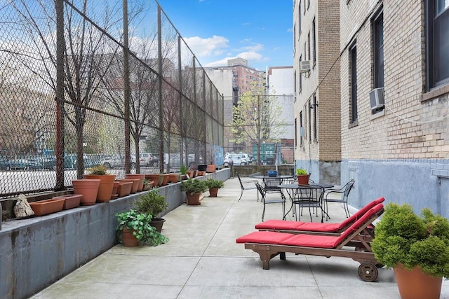 view of property's community featuring fence, a patio area, and outdoor dining space