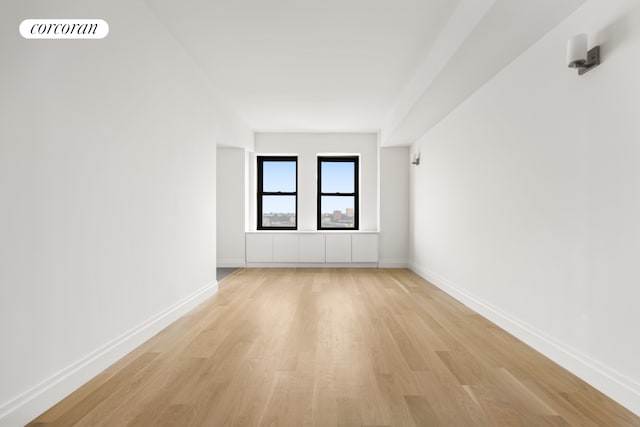 spare room with light wood finished floors and baseboards