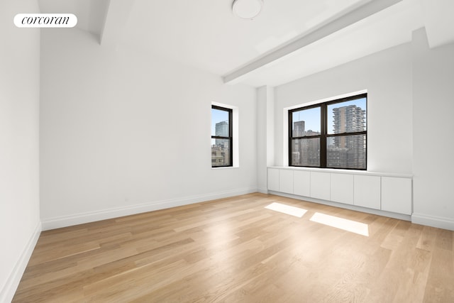 empty room with light wood-style floors and baseboards