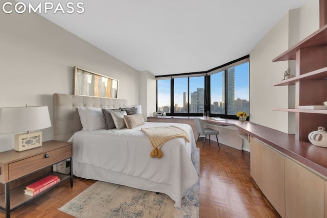 bedroom with dark parquet flooring and built in desk