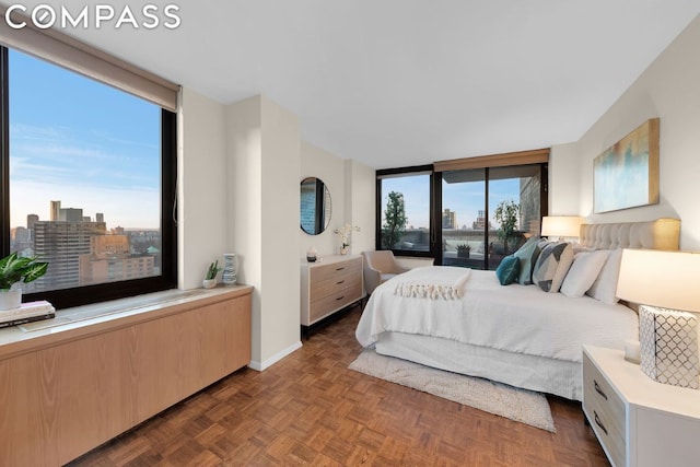 bedroom with a wall of windows and dark parquet floors