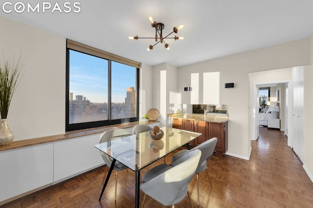 dining space featuring dark parquet flooring and a chandelier