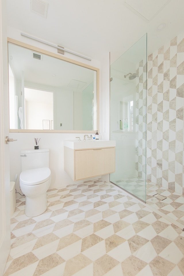 bathroom with toilet, visible vents, a walk in shower, and vanity