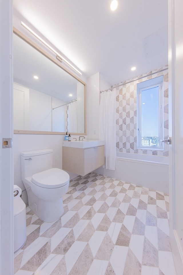 bathroom featuring toilet, recessed lighting, and vanity