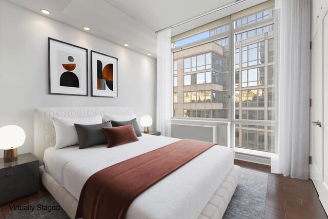 bedroom with dark wood-style floors, a wall of windows, and recessed lighting