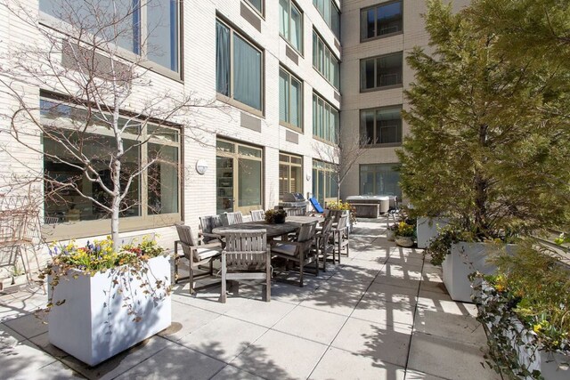 view of patio featuring outdoor dining area and a jacuzzi