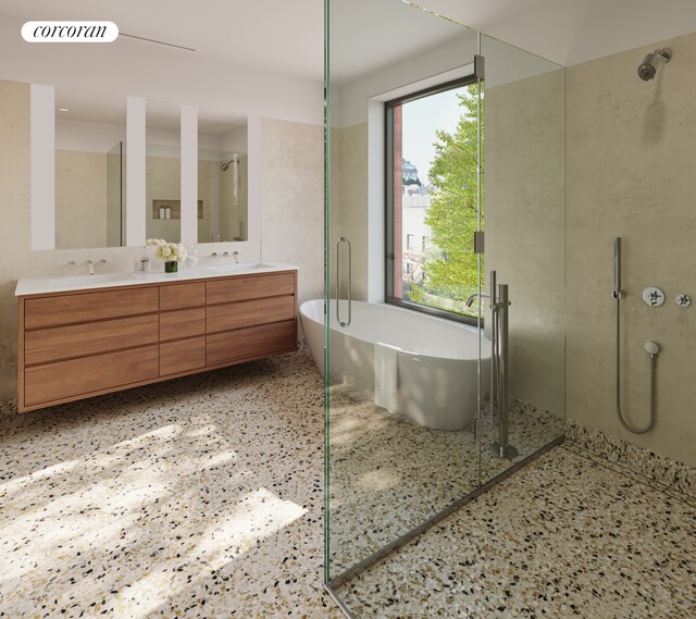 full bathroom featuring a sink, double vanity, speckled floor, a freestanding tub, and a walk in shower