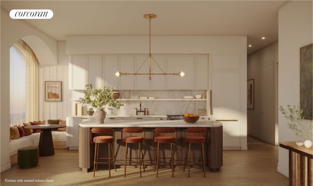 bar featuring decorative light fixtures, tasteful backsplash, white cabinetry, sink, and light wood-type flooring