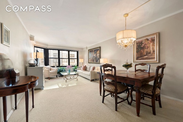 dining room with crown molding, a chandelier, and carpet floors