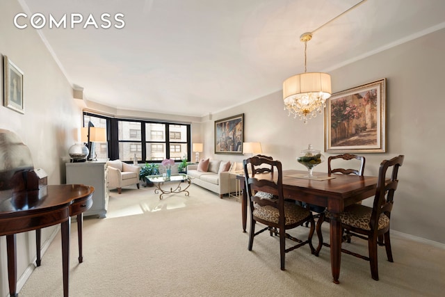 dining area with baseboards, carpet, an inviting chandelier, and ornamental molding