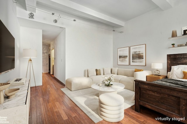 bedroom with beamed ceiling and hardwood / wood-style floors