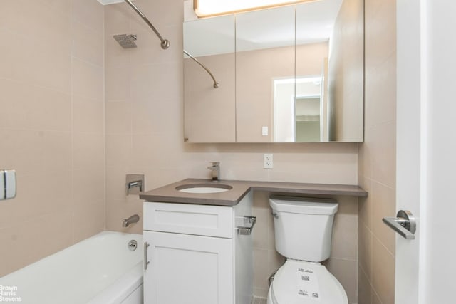 full bathroom featuring toilet, vanity, tile walls, tiled shower / bath, and decorative backsplash