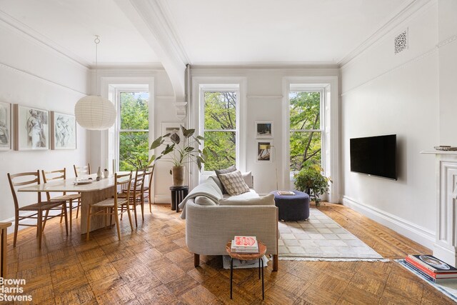 living room with a wealth of natural light, ornamental molding, and parquet floors