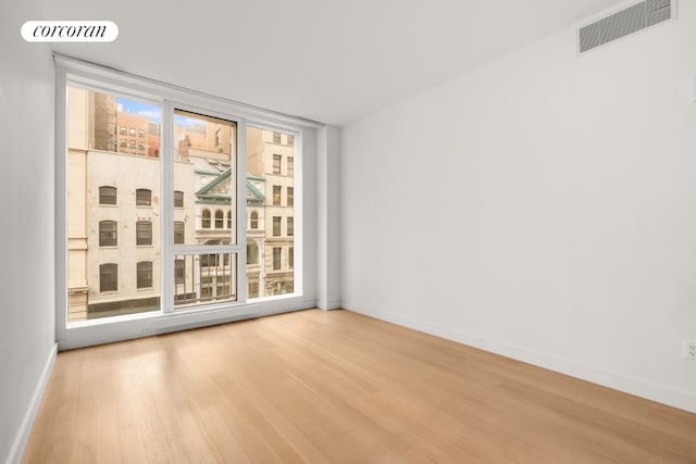 empty room featuring hardwood / wood-style flooring and expansive windows