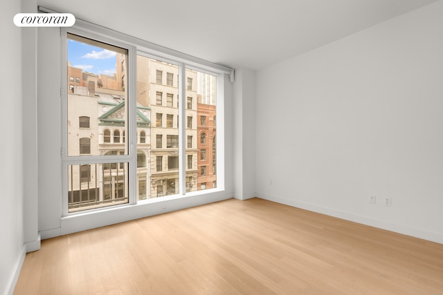 empty room featuring wood finished floors and baseboards