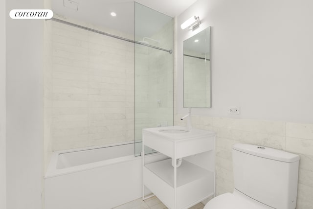 full bathroom featuring a wainscoted wall, tub / shower combination, recessed lighting, tile walls, and toilet