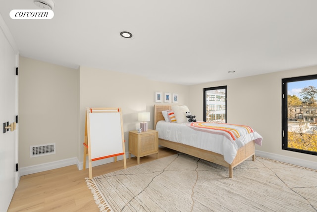 bedroom with visible vents, baseboards, and wood finished floors