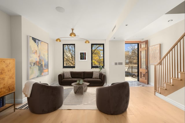 living area with baseboards, visible vents, wood finished floors, stairs, and recessed lighting