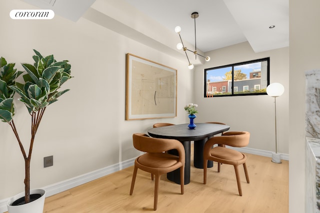 dining room featuring light wood finished floors, visible vents, and baseboards